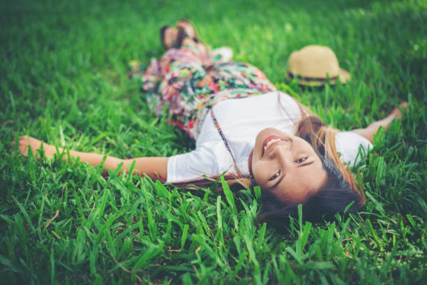 istock Young woman lying down on grass. relax time. 956943238