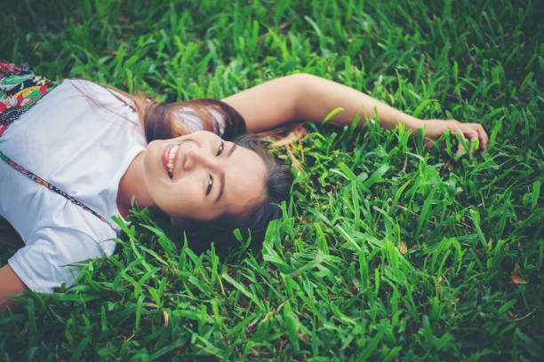 istock Young woman lying down on grass. relax time. 956943368
