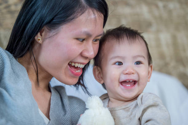 istock Mother and baby boy laughing together 956945470