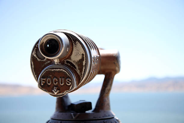 Close-up of telescope with defocused coastline in background telescope on the view platform of San Luis Reservoir California. image focus technique stock pictures, royalty-free photos & images
