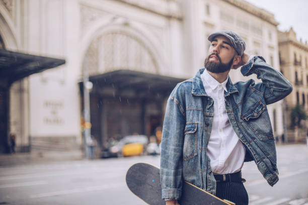 istock Handsome man carrying skateboard on the street 956954520