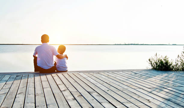 istock Father with his son enjoying lake view 956955086