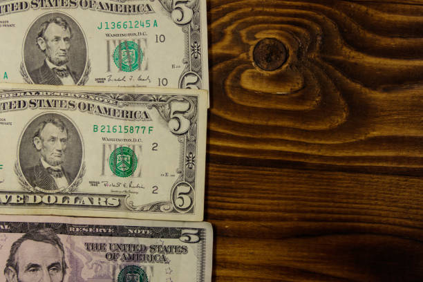 istock Five dollars banknotes on wooden background. Top view 956955346