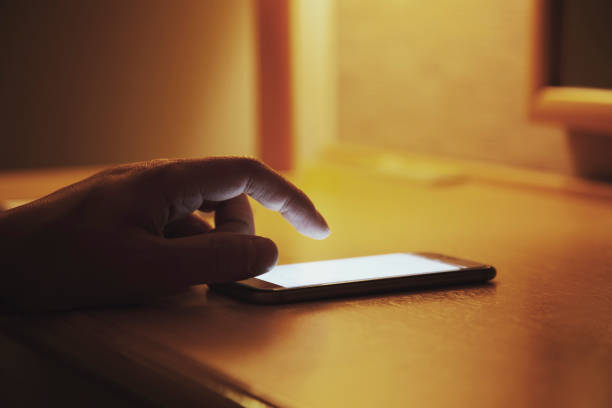 istock Business man using a smart phone at hotel at night 956955360