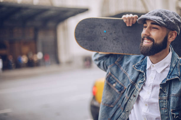 istock Man carrying skateboard on the shoulder 956955412