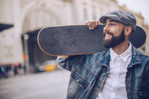 istock Handsome man carrying skateboard on the shoulder 956955832