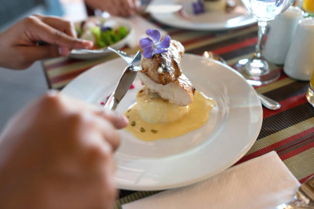 Close up of delicious chicken over mashed potato with sauce and decorated with a flower