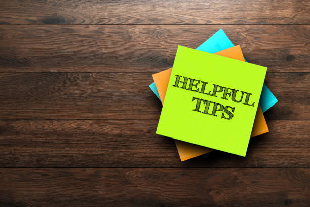 istock Helpful Tips, the phrase is written on multi-colored stickers, on a brown wooden background. Business concept, strategy, plan, planning. 956958862