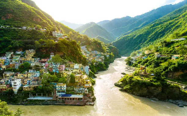 New edited version - Confluence of two rivers Alaknanda and Bhagirathi give rise to the holy river of Ganga / Ganges at one of the five Prayags called Dev Prayag. Uttarakhand river. Sunrise & greenery