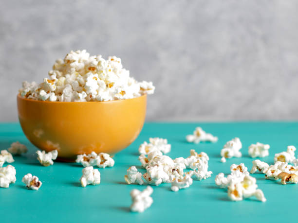 istock Popcorn in bowl on blue wood background 956963606