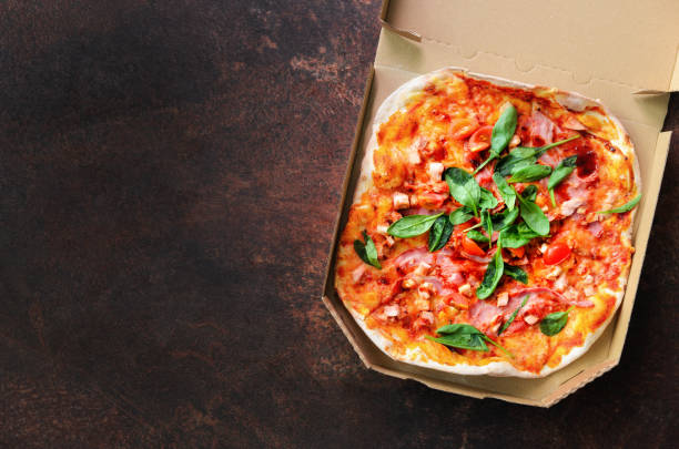 istock Fresh pizza in delivery box on dark concrete background. Top view, copy space 956967748
