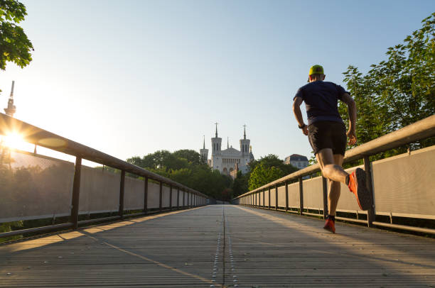 Spring run in Lyon Athlete running at Notre-Dame de Fourviere in Lyon on a beautiful summer morning. Lyon, France. fourviere stock pictures, royalty-free photos & images