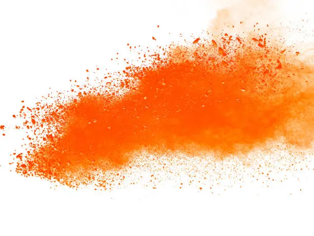 Photo of Explosion of orange powder on white background