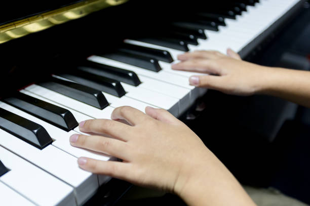 istock hands of kid playing piano 956969362