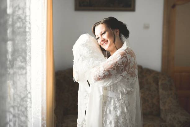istock Luxury bride in white dress posing while preparing for the wedding ceremony 956969828