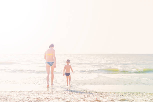 istock Mother and child on the tropical beach, toned image, copy-space. 956970032