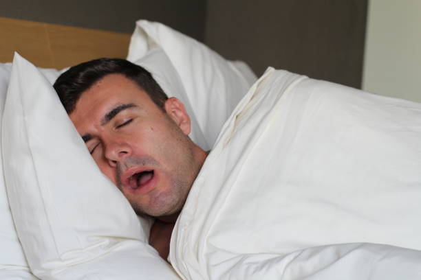 Funny man snoring in bed Funny man snoring in bed. Saliva stock pictures, royalty-free photos & images