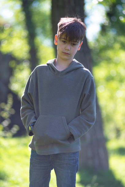 istock Dreaming boy stands in the forest among green trees 956977922