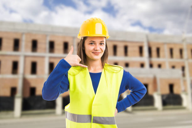 istock Young attractive female architect making call gesture 956988844