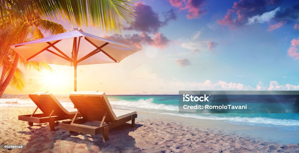 Two Deckchairs Under Parasol In Tropical Beach At Sunset Chairs Under Umbrella In Palm Beach At Sunset Beach Stock Photo