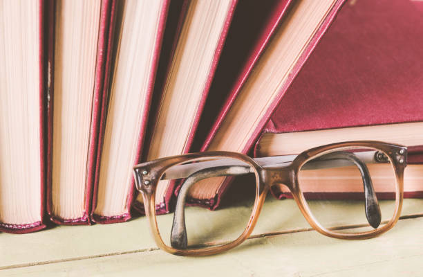 istock Old glasses with a pile of books 956990362