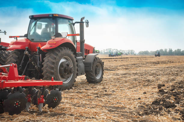 istock Red tractor in the field on a bright sunny day. 956990950