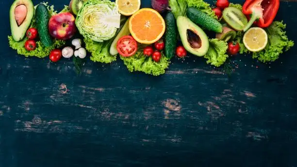 Healthy food. Vegetables and fruits On a black wooden background. Top view. Copy space.