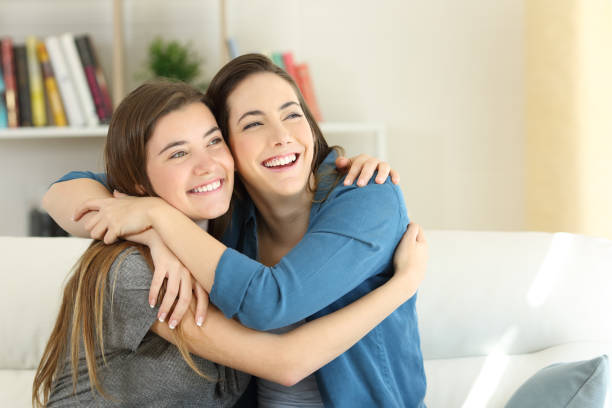 istock Two happy friends or sisters hugging at home 956997066