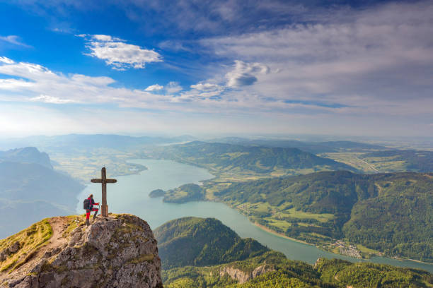 trepador de la montaña en la cumbre de cruz en la cima de monte schafberg, alpes - mountain austria european alps mountain peak fotografías e imágenes de stock