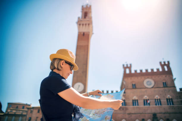 mujer de turismo con el mapa en la piazza del campo en siena - sun sunlight italy florence italy fotografías e imágenes de stock