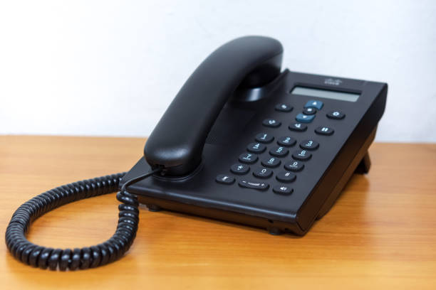 istock Black ip telephone device on wooden table 957001166