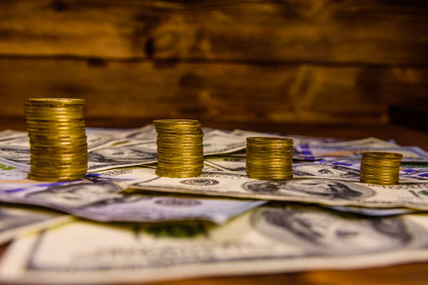 istock Stack of the coins on the one hundred dollar bills 957002740