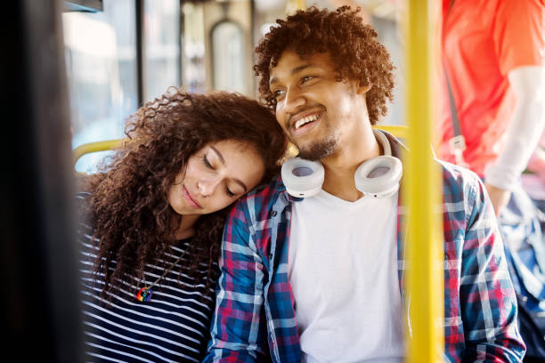 istock A young beautiful tired woman is leaned on a young cheerful mans shoulder and resting while he is smiling and looking through the window. 957006226