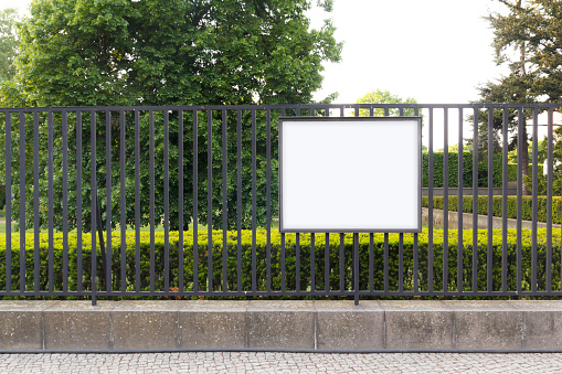 Blank billboard mock up, in the fence of a park