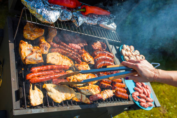 istock Grilling food on barbecue grill, hands preparing skewers 957009736