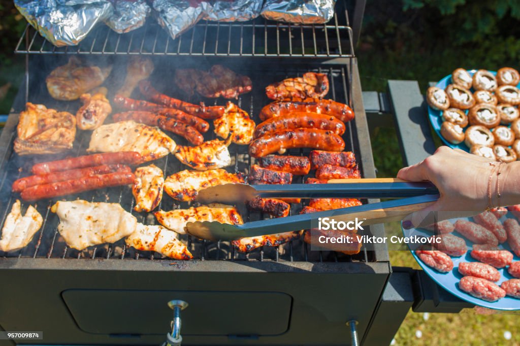 Grilling food on barbecue grill, hands preparing skewers Barbecue - Meal Stock Photo