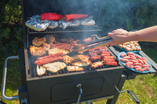 istock Grilling food on barbecue grill, hands preparing skewers 957009988
