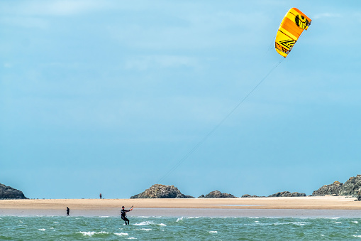 NEWBOROUGH / WALES - APRIL 26 2018 : Kite flyer surfing at Newborough beach - Wales - United Kingdom