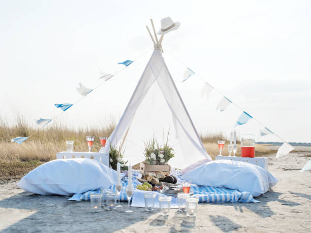 Romantic Camping Trip for Two Lovely romantic glamping for two on a wild seashore. Unique way to celebrate your love. teepee tent on the beach stock pictures, royalty-free photos & images
