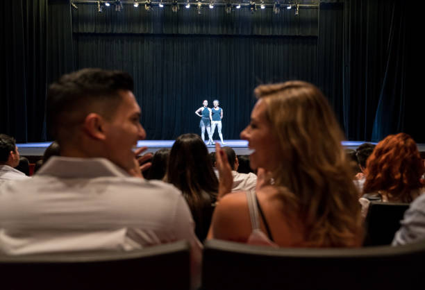 jong (echt) paar op een datum bij ballet applaudisseren en kijken elkaar lachend - theater publiek stockfoto's en -beelden