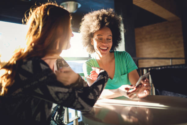 Friends looking at the mobile phone at the cafe