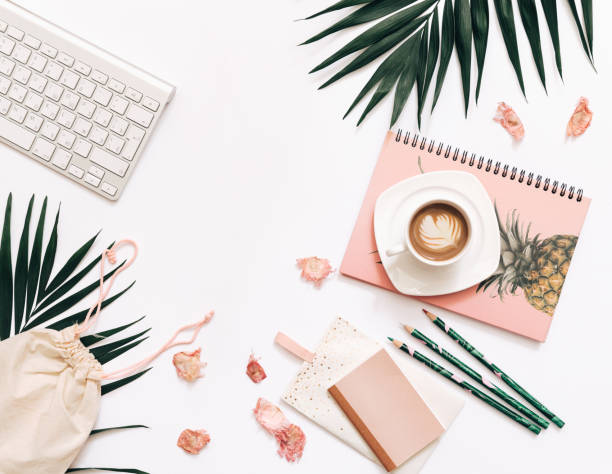 Flat lay blogger workspace mockup with tropical leaves , coffee and accessories on white background. Copy space