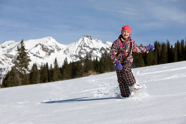 snowshoeing winter hiking. Active couple on snowshoes outdoors in snow walking in natural park in Canada, Quebec.