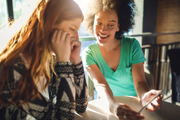 istock Girlfriends looking at the mobile phone 957035132