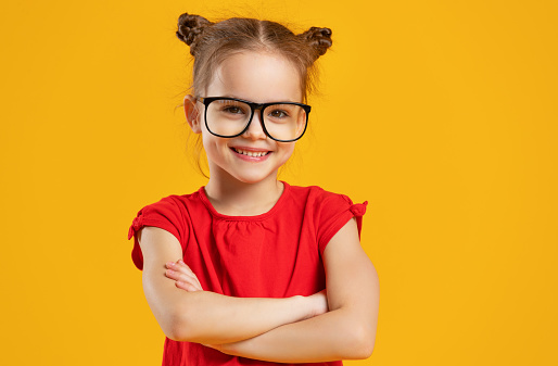 funny child girl wearing glasses on a colored background
