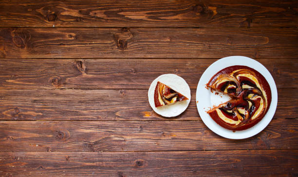 Chocolate cake and piece of chocolate cake on wooden background. Top view with copy space