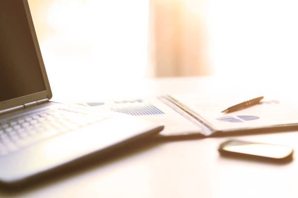 istock Analysis of graphics and calculations on a laptop with documents in the office 957047004