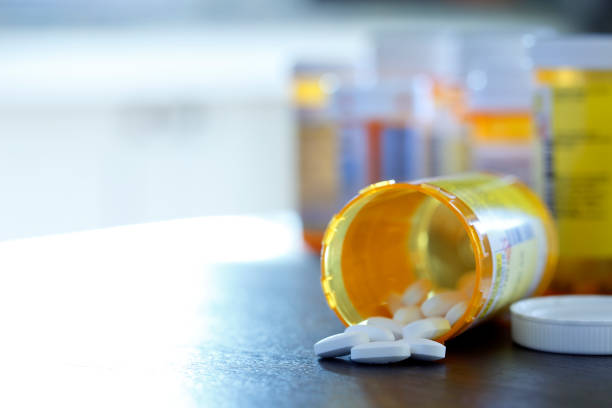 bottiglia di farmaci da prescrizione aperta sul piano di lavoro - drug bottle foto e immagini stock