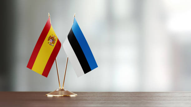 istock Spanish And Estonian Flag Pair On A Desk Over Defocused Background 957053436