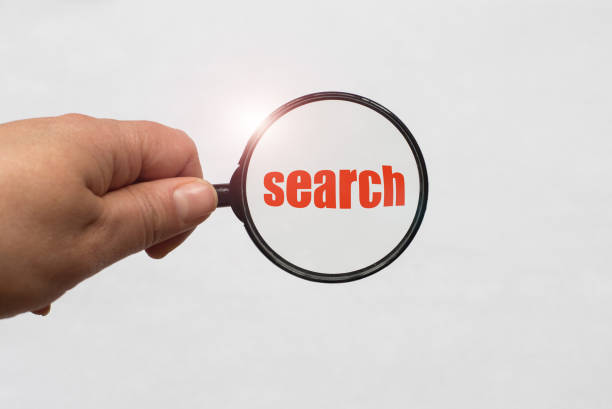 istock Text search and a magnifying glass on white background 957058648